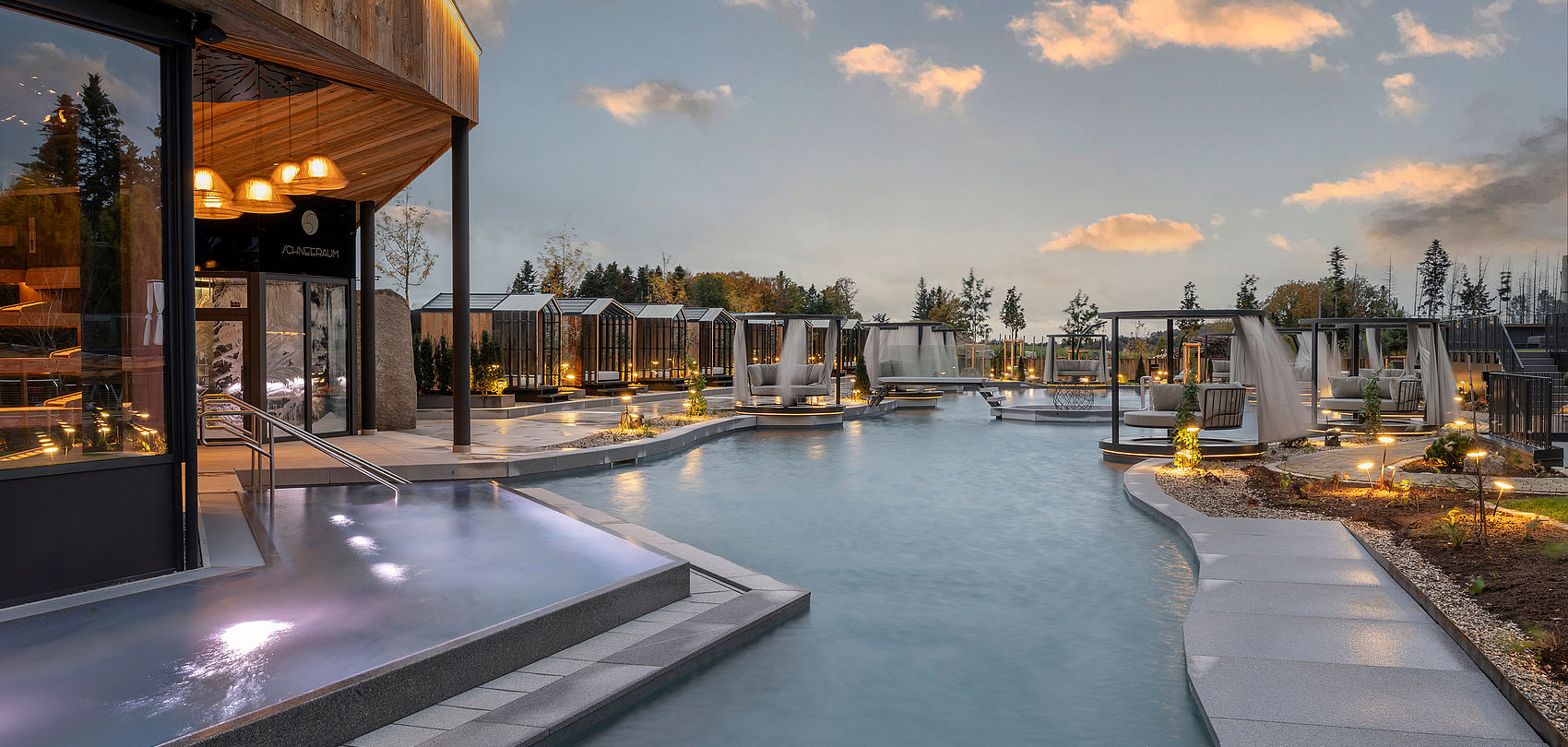 Moderne Wellness-Anlage mit Pool, Holzpavillon und privaten Cabanas in Abendstimmung
