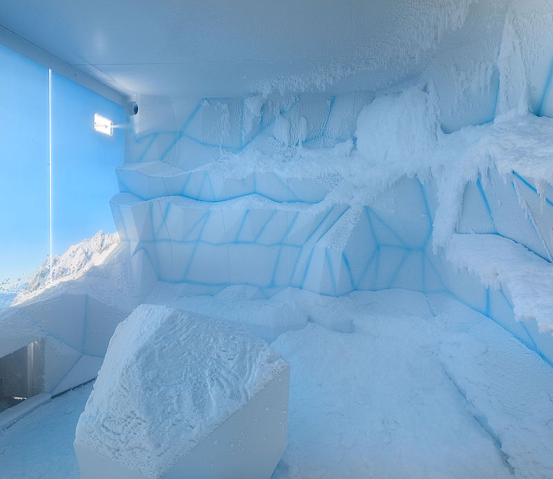 Modernes Schneeraum-Interieur mit blau beleuchteten Eiswänden und natürlicher Schneeoberfläche.