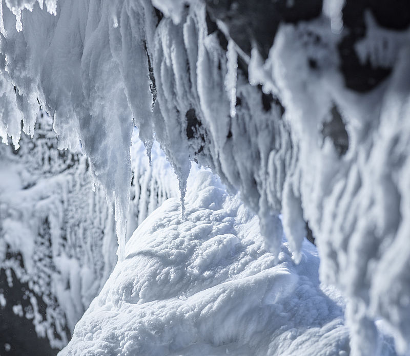 Detailaufnahme von Eiszapfen und Schneeformationen in einem Indoor-Schneeraum.