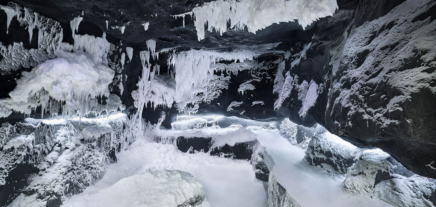 Eishöhlen-Design mit dunklen Felsen, weißen Eiszapfen und Schneeformationen im SnowRoom