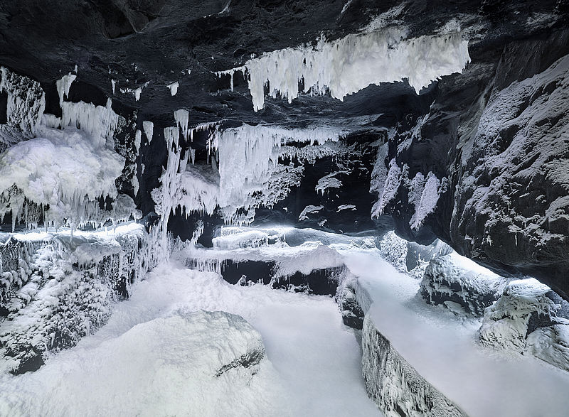 Ice cave design with dark rocks, white icicles and snow formations in SnowRoom