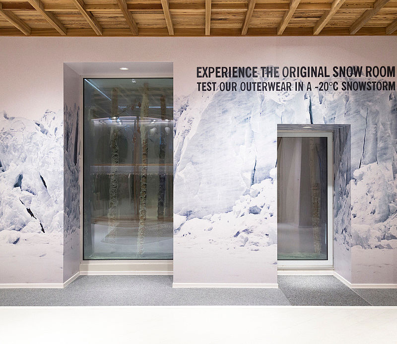 Eingang zum Snow Room mit Gletscher-Wandgrafik und Test-Outerwear-Hinweis in -20°C Snowstorm.