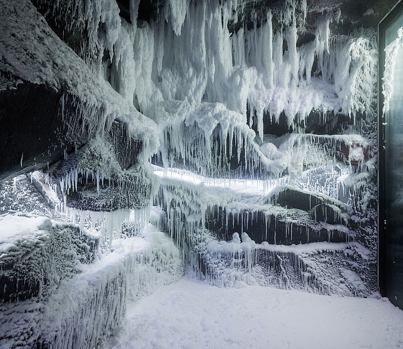 Eishöhle mit beeindruckenden Eiszapfen und Schneeformationen an Wänden und Decke im Wellness-Schneeraum.