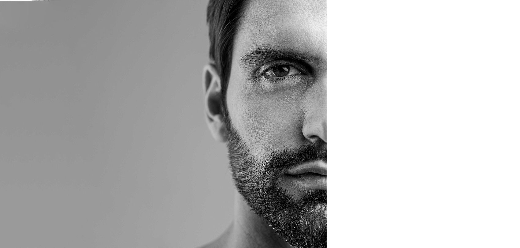 Black and white portrait of bearded man, half face cropped