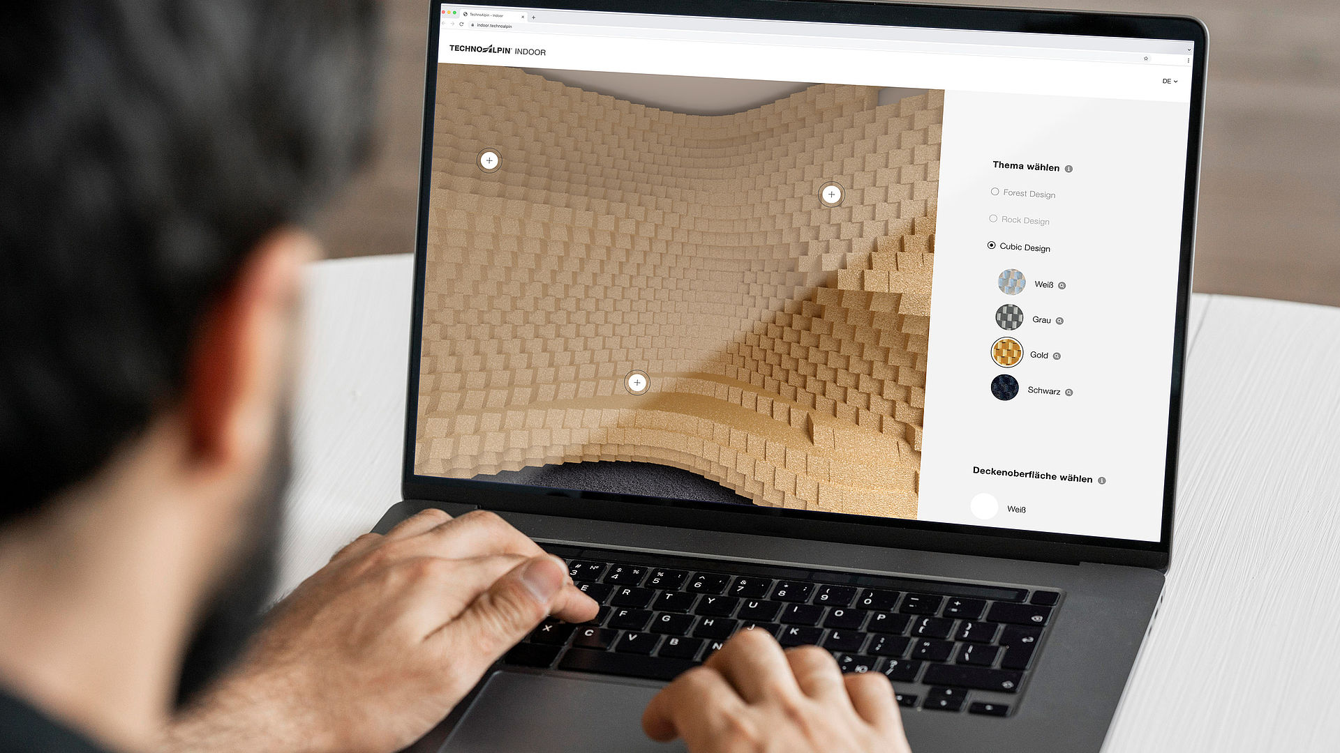 Personne configurant le design TechnoAlpin Indoor en ligne avec différentes options de surfaces murales.