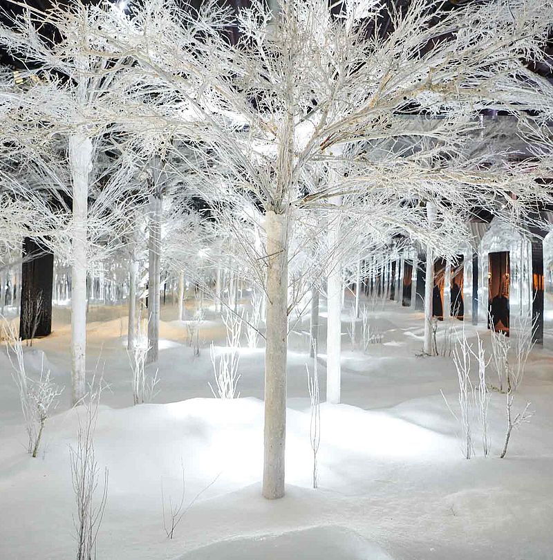 Künstlicher Schneewald mit weißen Bäumen und Schneehügeln in Indoor-Installation